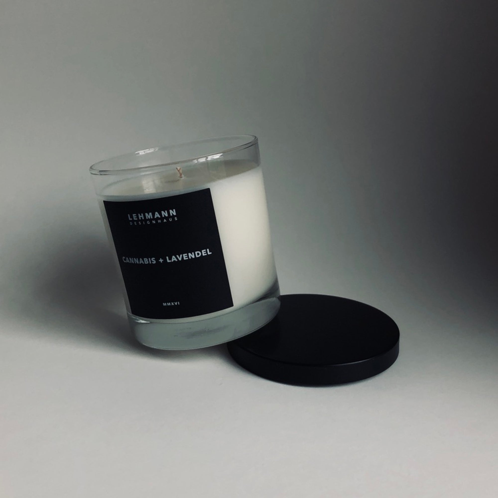 Picture of Cannabis and Lavendel Candle sitting on black lid against white backdrop.